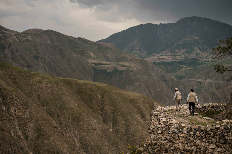 Two WFP staff are walking in the mountain 
