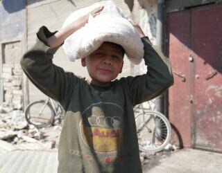 시리아 알레포에서 식량을 받아 집으로 향하는 아이. Photo: WFP/Hussam Al Saleh