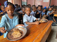  Photo: WFP/Alexis Masciarelli, primary school children eat their hot meal in their classroom at the Catherine Flon state school, in the city of Jeremie, Haiti.
